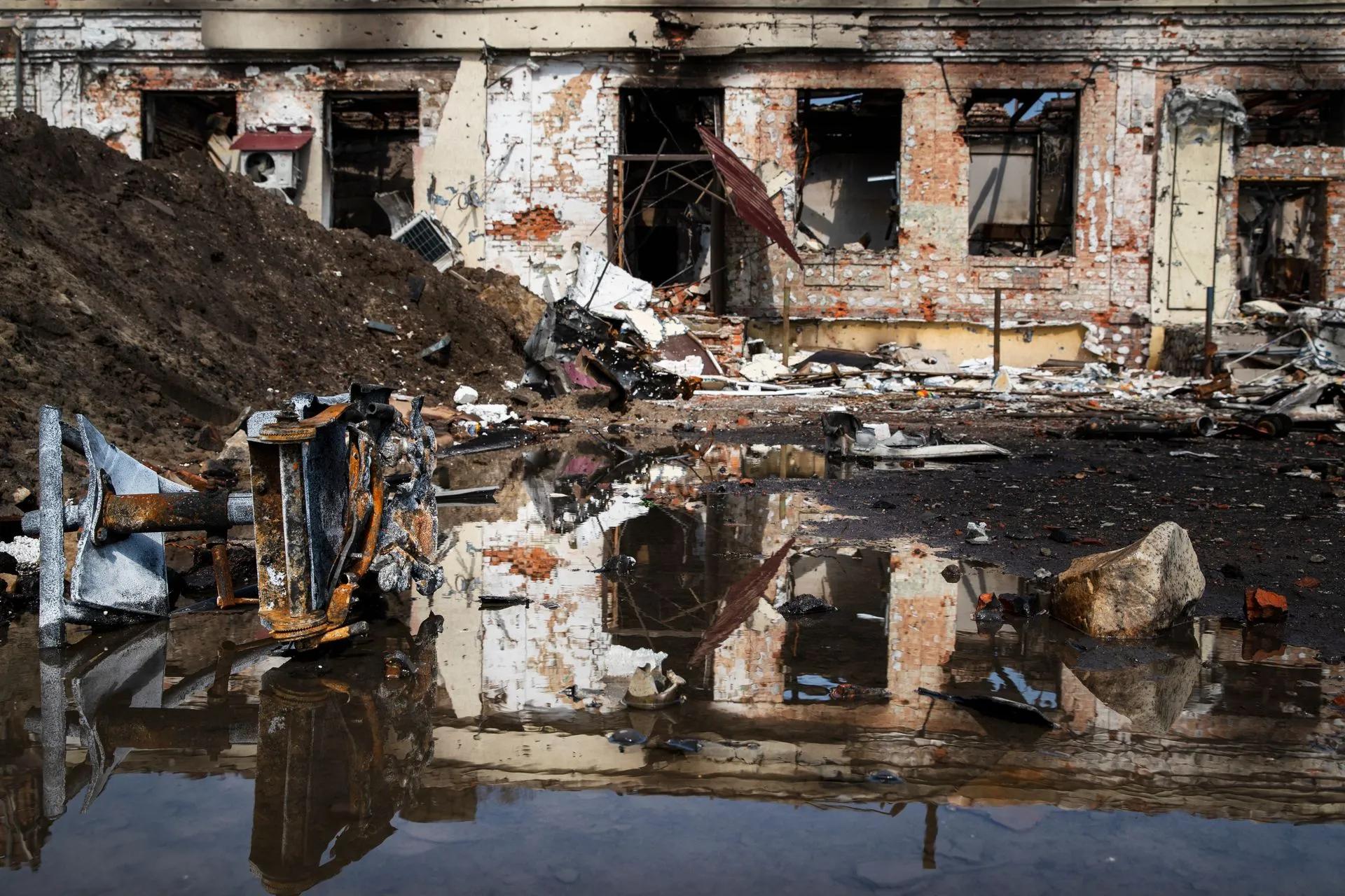 A building damaged by flooding, with broken windows and debris.
